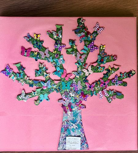 A craft piece of a tree with butterflies across it